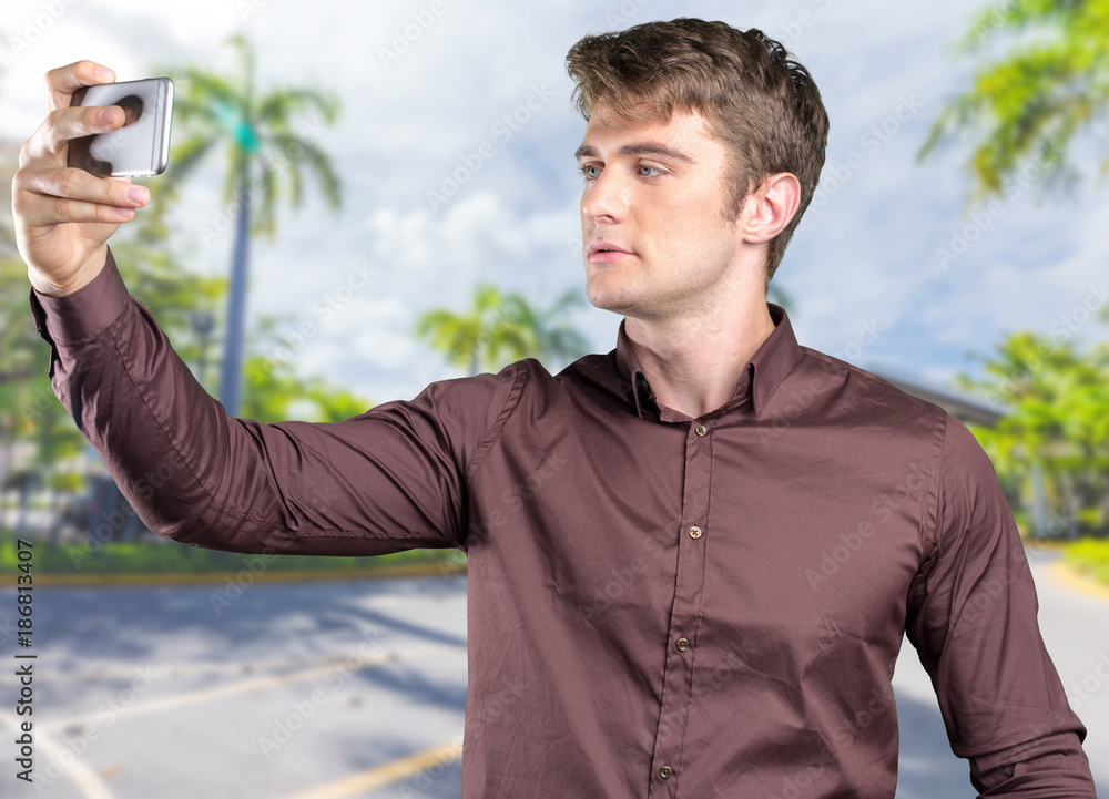 Casual young man tourist taking selfie in a journey using his smartphone Casual young man tourist taking selfie in a journey using his smartphone