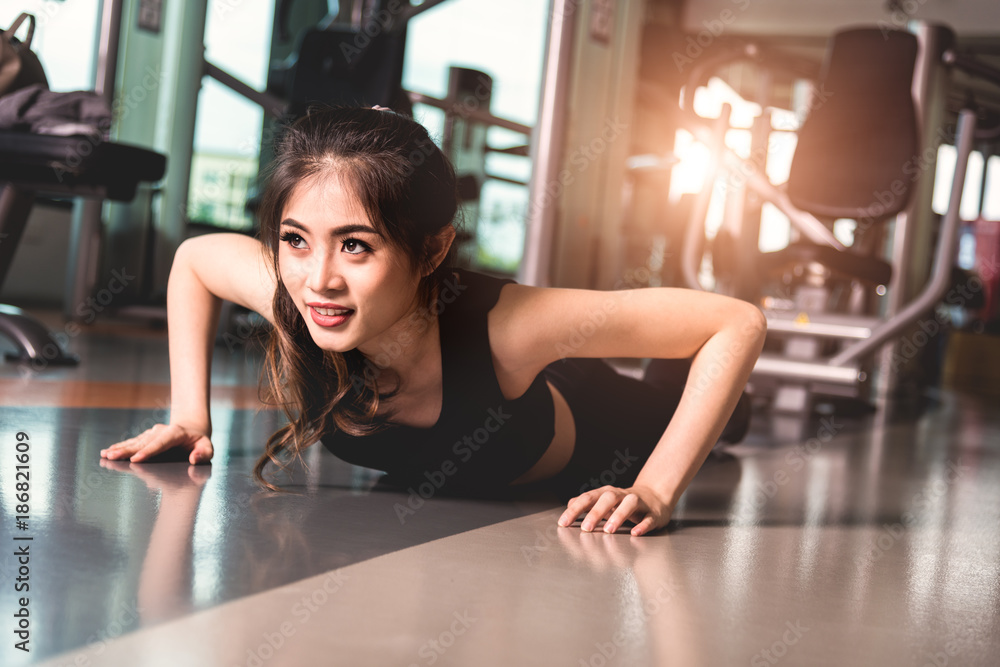 Woman warming up and doing some push ups in gym Woman warming up and doing some push ups in gym
