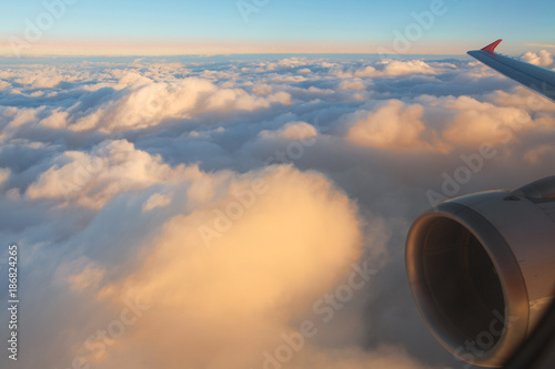 View of the sunset,clouds and airplane wing from the Inside