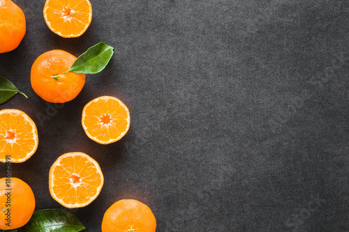 Beautiful, fresh, orange mandarins on the dark background. Healthy sweet food concept. Mock up for fruits offers as advertising or web background, or other ideas. Empty place for text or logo.