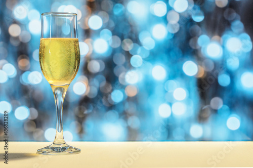 Glass of champagne on background of bright lights, Christmas and New Year concept