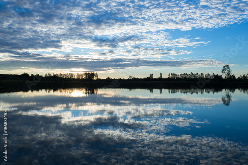 Morning scenery with clouds and sky reflecting surface.