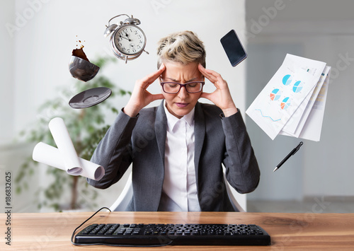 Businesswoman working on a laptop, overworking, under pressure   photo