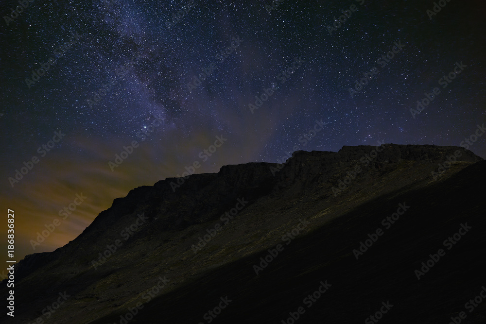 Night starry sky. The Milky Way in the background of a mountain range.