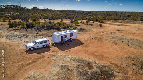 Aerial view of four wheel drive vehicle and caravan camped in the outback of Australia.