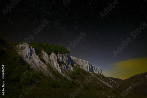 Night starry sky. View of the cliff in the moonlight.