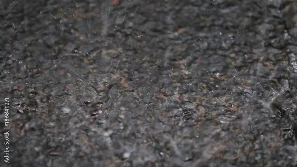 Tropical rain drops falling on the stone surface in garden. Bali, Indonesia. Close up Tropical rain drops falling on the stone surface in garden. Bali, Indonesia. Close up