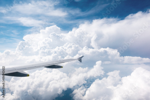 View on thunderstorm clouds and wing of airplane from window