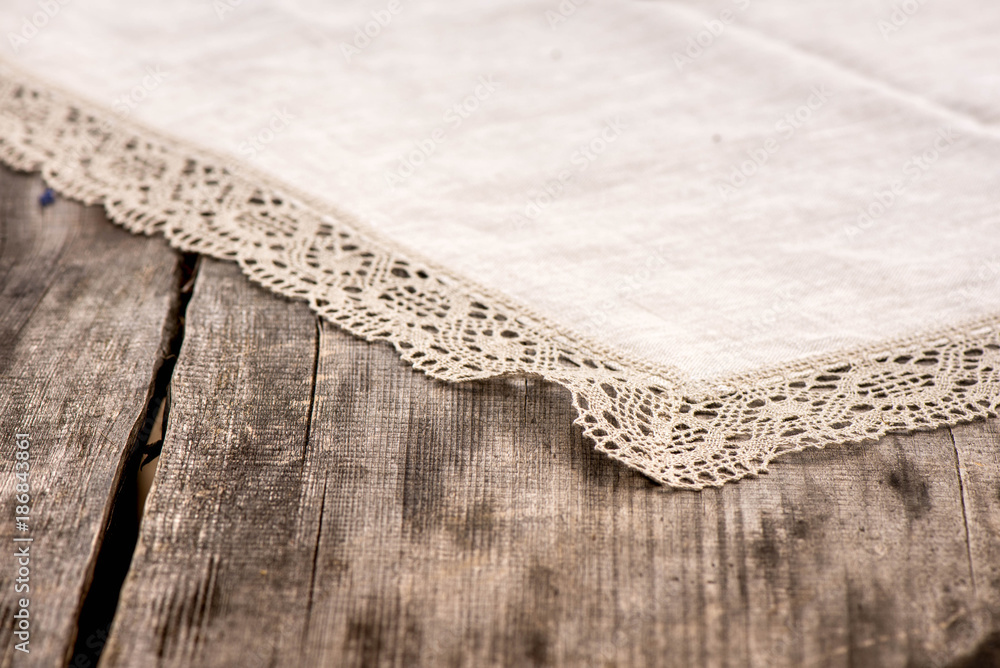 Shot of linen tablecloth with grey crochet lace trim on a wooden table Shot of linen tablecloth with grey crochet lace trim on a wooden table
