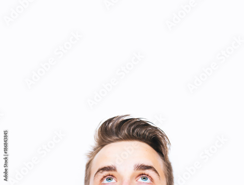 Close up of young man eyes looking up and white background