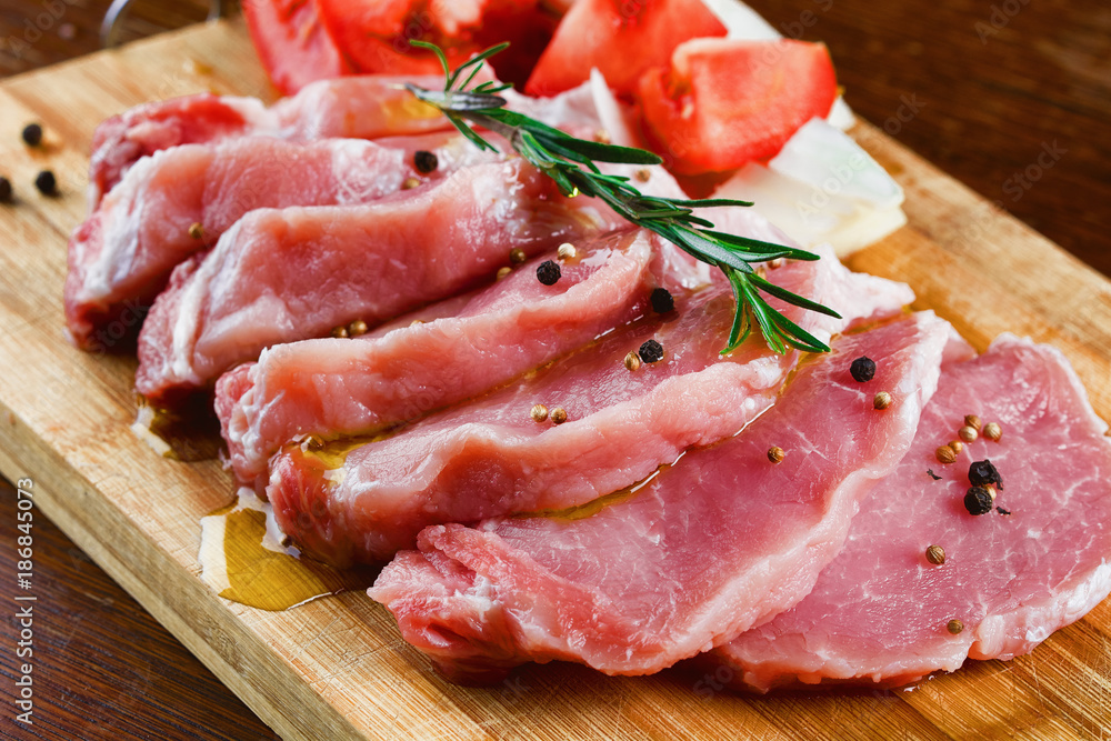 Slices of meat being seasoned for preparation. Slices of meat being seasoned for preparation.