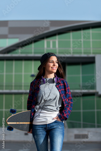 Smiling female with skate and headphones