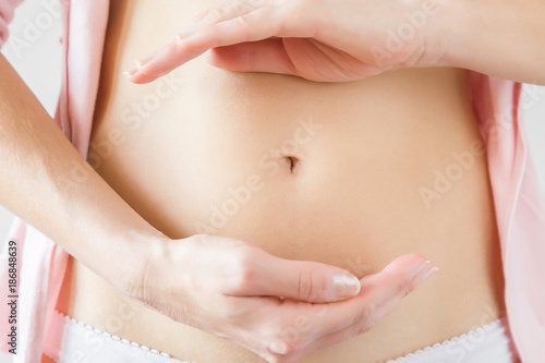 Young woman s hands reflecting a stomach wellness. Healthy eating concept. 