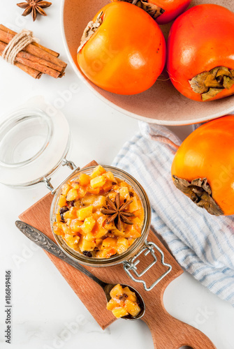 Traditional indian food recipes, Persimmon fruit Chutney with cinnamon and anise stars, white marble background copy space top view