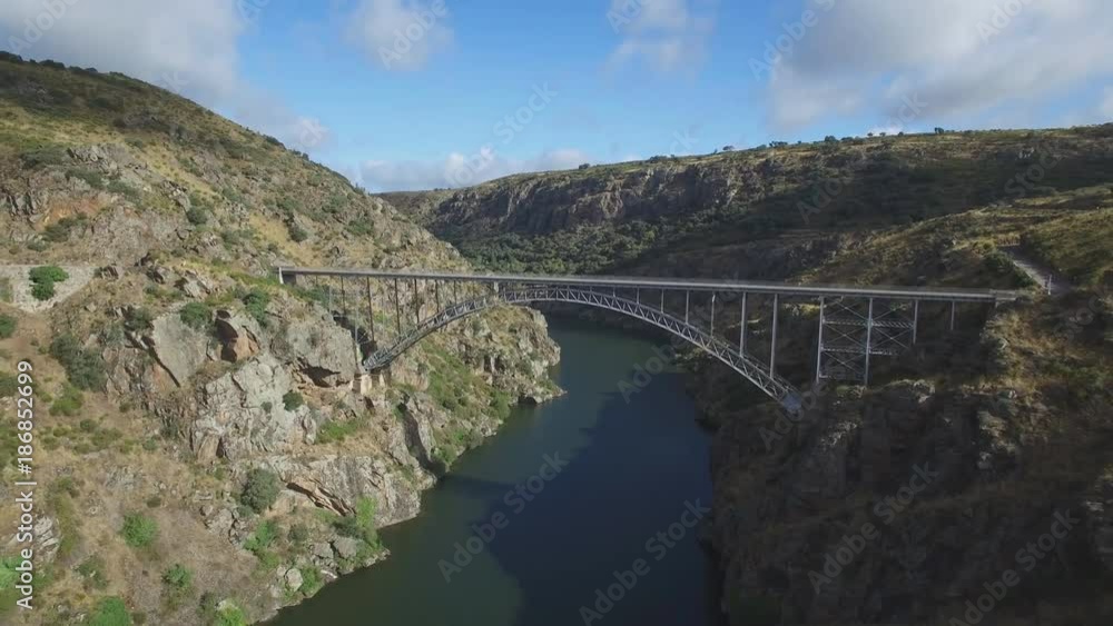 Aerial view of iron bridge over canyon with tourist walking Aerial view of iron bridge over canyon with tourist walking