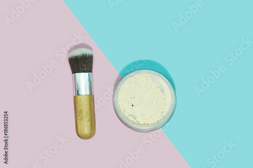 Make up powder with brush on blue and pink background