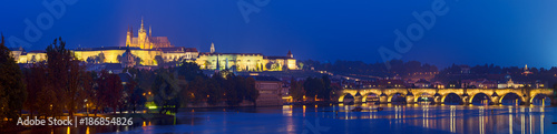 Night view of famous european Prague city - the capital of Czech republic with reflection in river Vltava and Charles Bridge. Panoramic view.