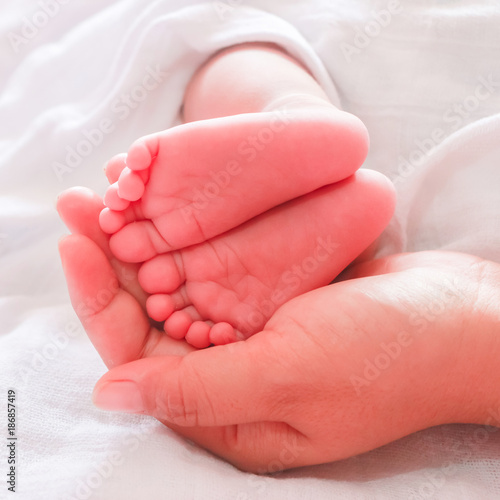 mother holding baby feet