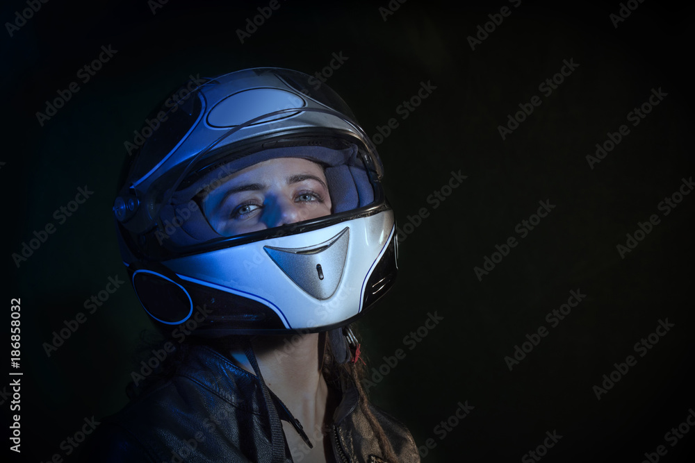 portrait girl dressed with motorcycle jacket while pull out the motorcycle helmet from the head portrait girl dressed with motorcycle jacket while pull out the motorcycle helmet from the head