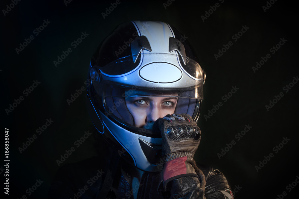 portrait girl dressed with motorcycle jacket while pull out the motorcycle helmet from the head