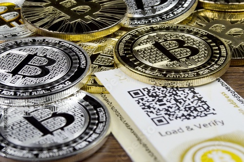 Bitcoin coins laying on paper wallet with QR code for contactless payment photo