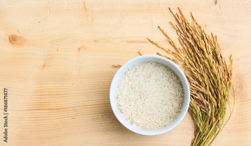 rice in bowl and ear of paddy on wooden. rice in bowl and ear of paddy on wooden.