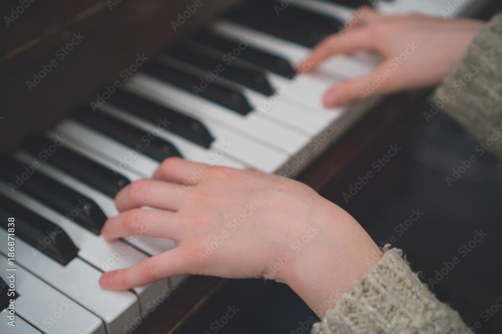 Fototapeta premium Child learns to play the piano.