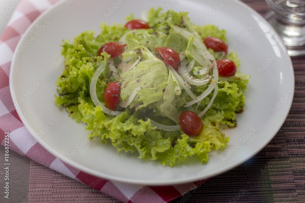 Salada fresca de vegetais misturados servida em um prato em uma mesa de madeira. conceito estilo de vida. Salada fresca de vegetais misturados servida em um prato em uma mesa de madeira. conceito estilo de vida.