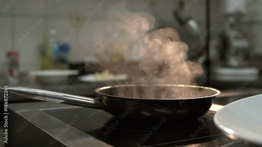 Hot frying pan on the oven. Presentation of the dish in the restaurant. Hot frying pan on the oven. Presentation of the dish in the restaurant.