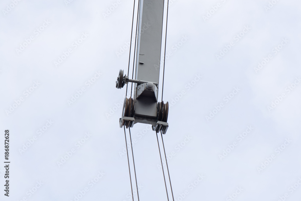 Shot of an old, rusty port crane preparing to lift cargo in ship on overcast sky background. Equipment for unloading ships and barges, preparing for export world wide Shot of an old, rusty port crane preparing to lift cargo in ship on overcast sky background. Equipment for unloading ships and barges, preparing for export world wide