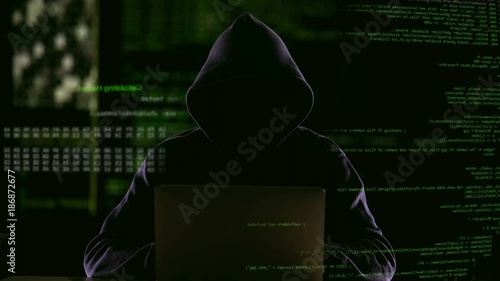 Hacker opening laptop to check virus breaking system codes, stealing data