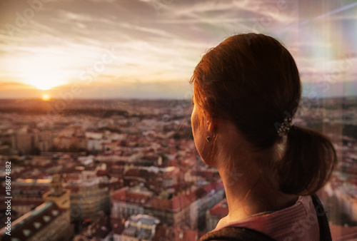 Woman watching on sunset over city