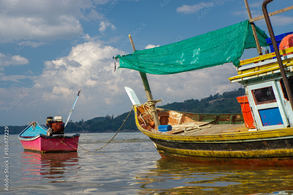 THAILAND, PHUKET, ASIA - JANUARY 28, 2016: Thai old fishing small boat at low tide in the shallows.