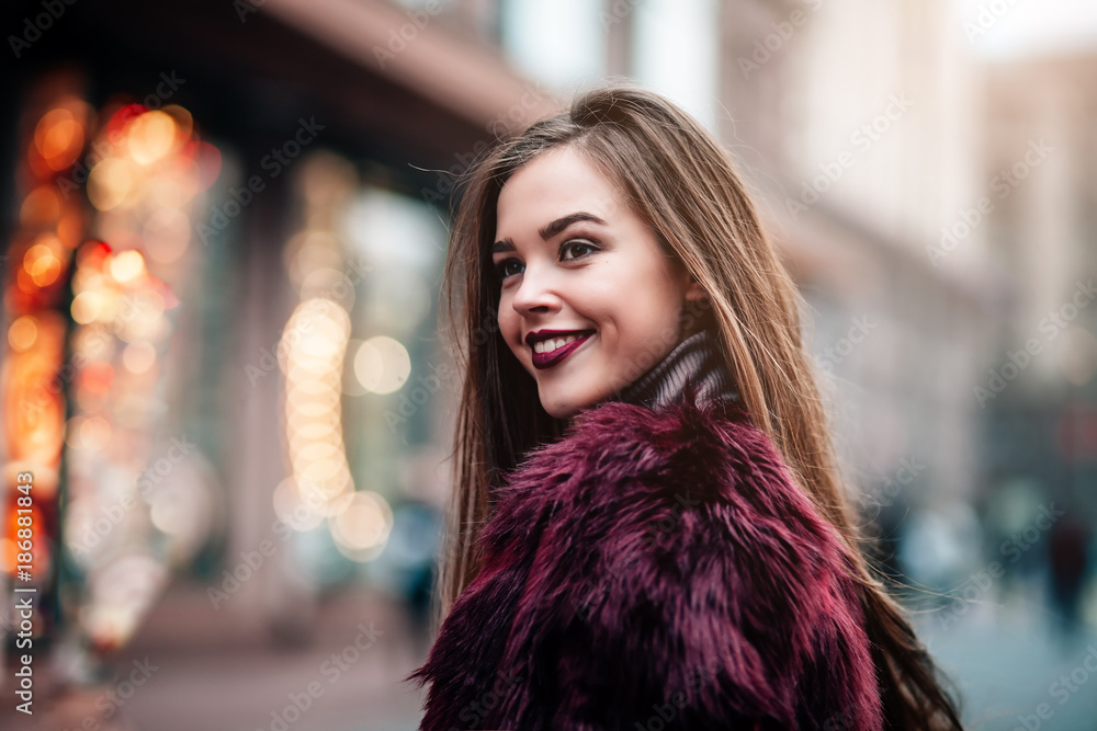 Outdoor portrait of young beautiful happy smiling girl posing on street. Model wearing stylish warm clothes. concept of street fashion
