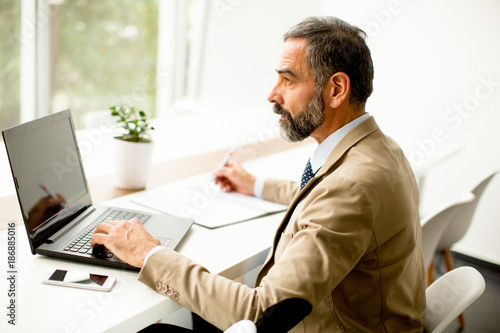 Senior businessman working on laptop computer in office