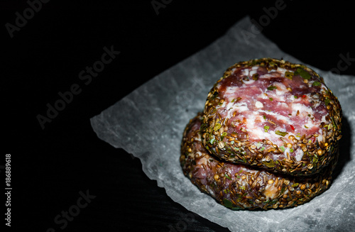 raw beef meat burger steak cutlets beefsteack on paper on dark wooden background. with copy space. photo