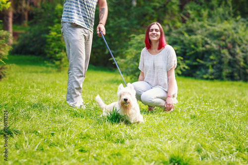 Couple having fun with them dog in park