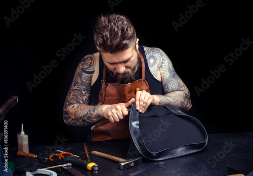 Artisan at work on his new leather product in his workplace © Stop war in Ukraine!