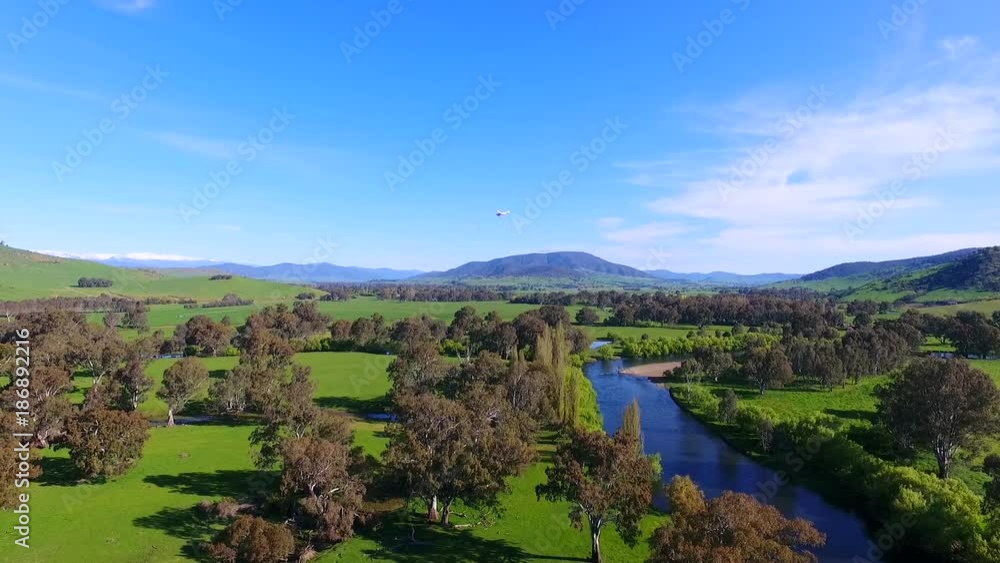 Toy plane soars over Australian countryside, pan left aerial Toy plane soars over Australian countryside, pan left aerial