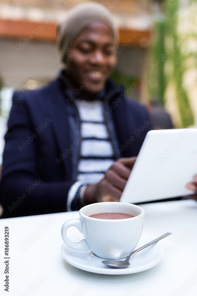 Handsome young man using his digital tablet in the cafe. Handsome young man using his digital tablet in the cafe.