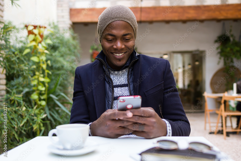 Handsome young man using his mobile phone in the cafe. Handsome young man using his mobile phone in the cafe.