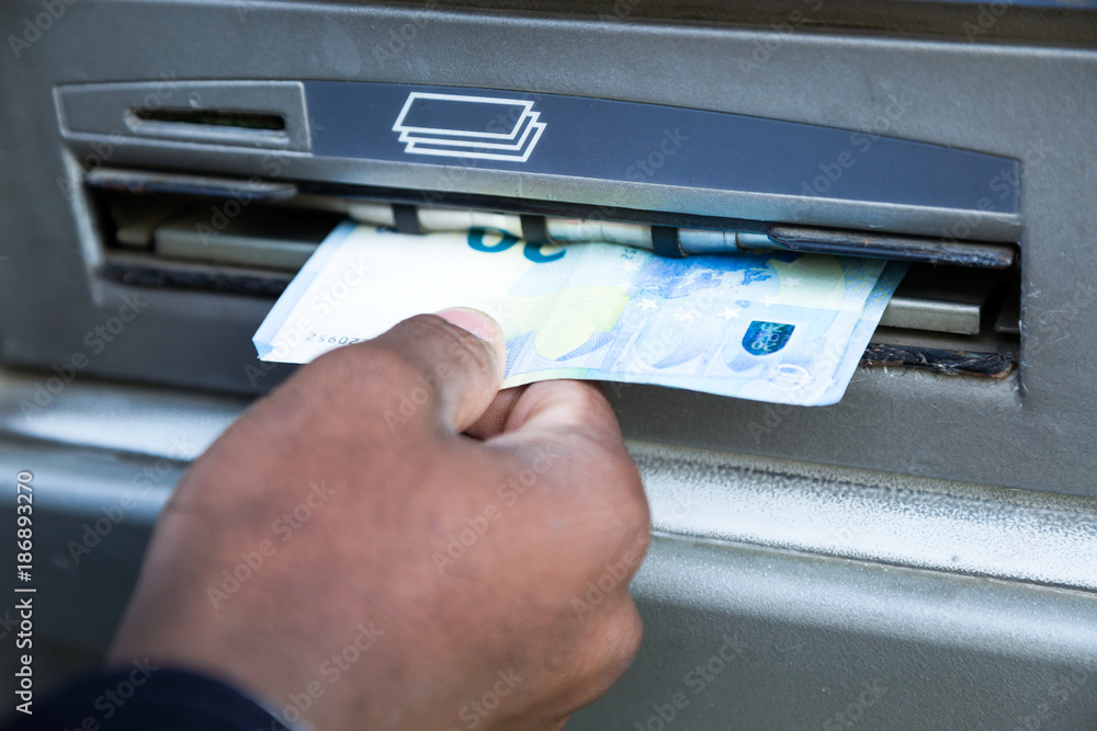 Close up of man taking cash from ATM with credit card. Close up of man taking cash from ATM with credit card.