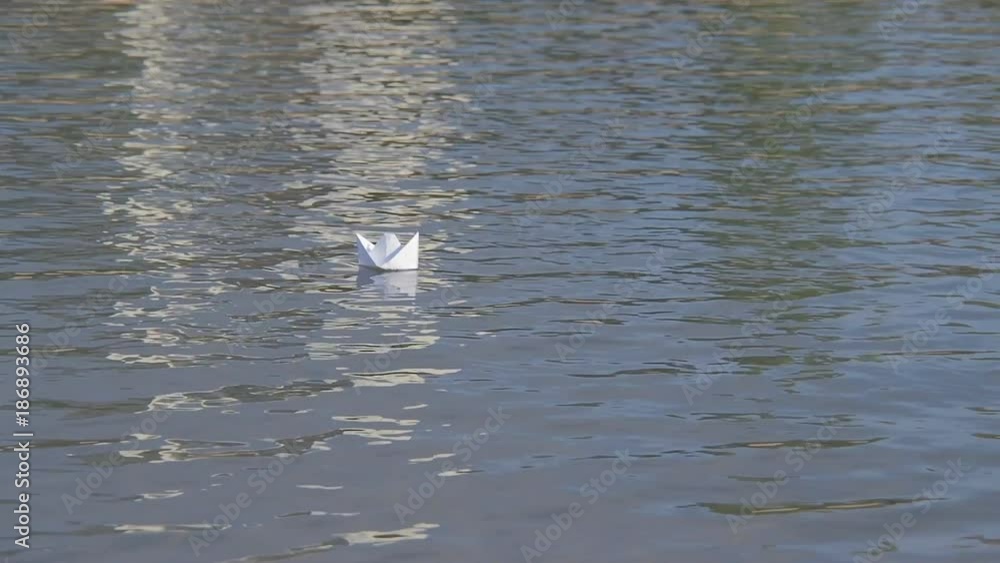 A paper boat sails along the river. A paper boat sails along the river.