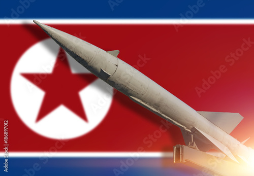 Rocket against the background Flag of North Korea. Weapons of mass destruction. Missiles with warheads. Nuclear weapons, chemical weapons.