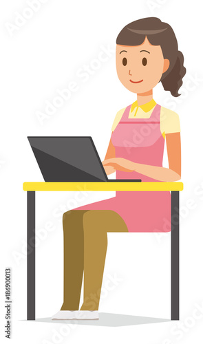 A female home helper wearing an apron is operating a laptop computer