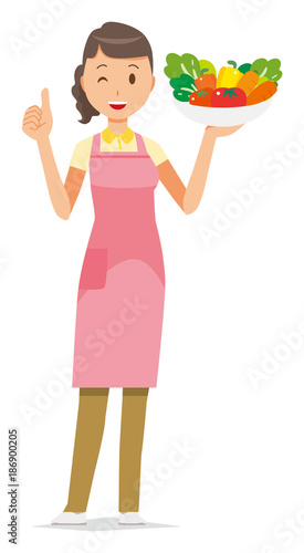 A female home helper wearing an apron has vegetables