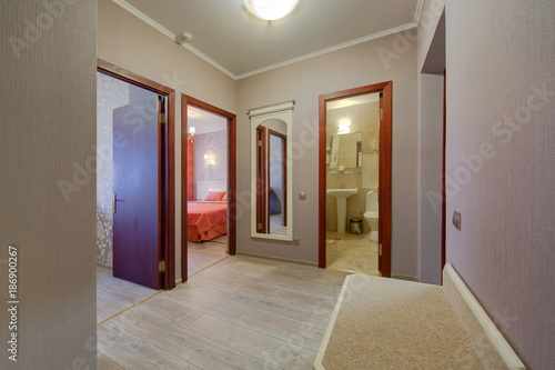 A corridor with an exit to the toilet room  to the bedroom and in an office