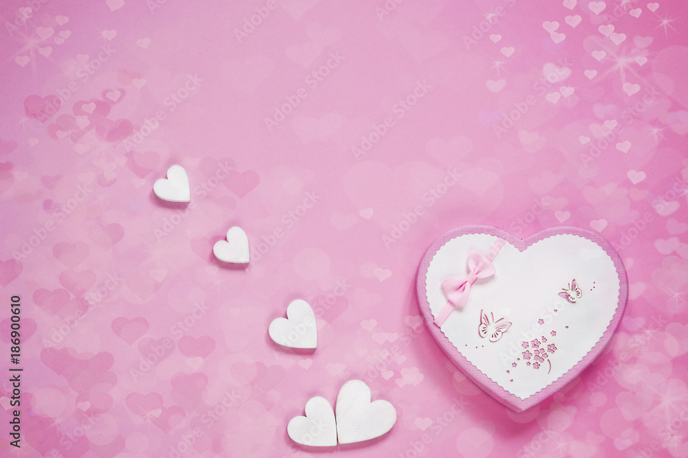 Gift box in the form of a heart on a pink paper background. The concept for the Valentine's Day, wedding, engagement and other romantic events. Top view, close-up.