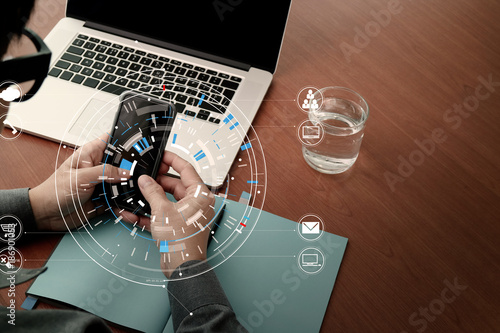Fototapeta Naklejka Na Ścianę i Meble -  close up of businessman working with smart phone and digital tablet and laptop computer  on wooden desk in modern office with virtual icon diagram