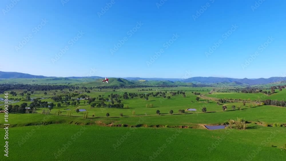 Toy plane soars over Australian countryside, pan right aerial Toy plane soars over Australian countryside, pan right aerial